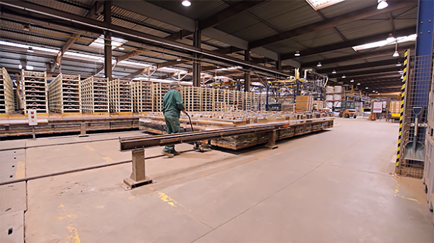 Worker pushing materials along industrial factory line